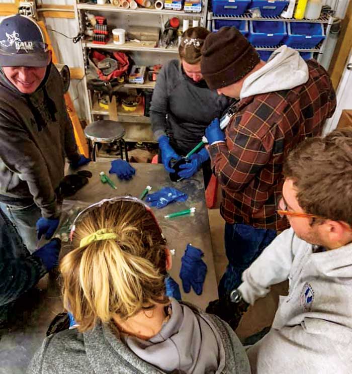 Group of farrier students participate in a product demonstration.